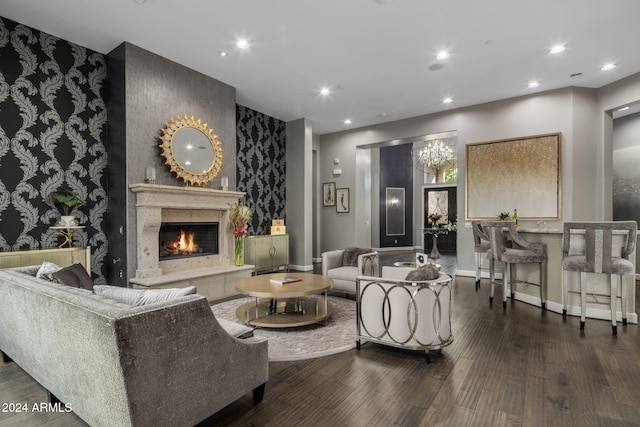 living room featuring a high end fireplace, dark hardwood / wood-style floors, and a notable chandelier