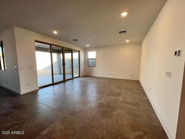 unfurnished room featuring dark tile patterned flooring