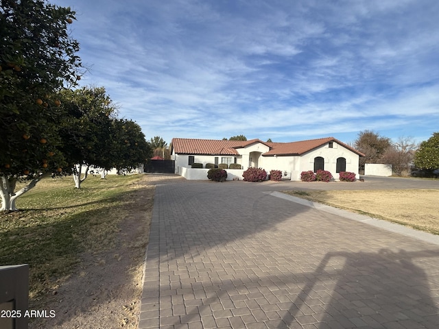 18132 E Vencino St, Gilbert, AZ 85298 - mediterranean / spanish-style house featuring curved driveway, stucco siding, a tile roof, and a front yard