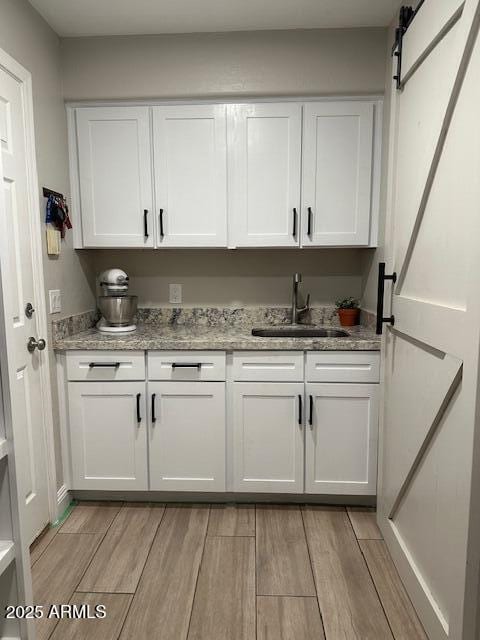 18132 E Vencino St, Gilbert, AZ 85298 - bar area featuring a sink, light wood finished floors, and a barn door