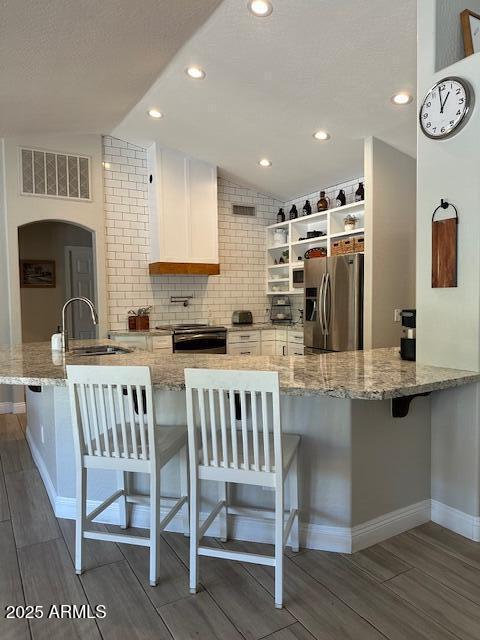 18132 E Vencino St, Gilbert, AZ 85298 - kitchen with appliances with stainless steel finishes, a sink, open shelves, dark wood-style flooring, and vaulted ceiling