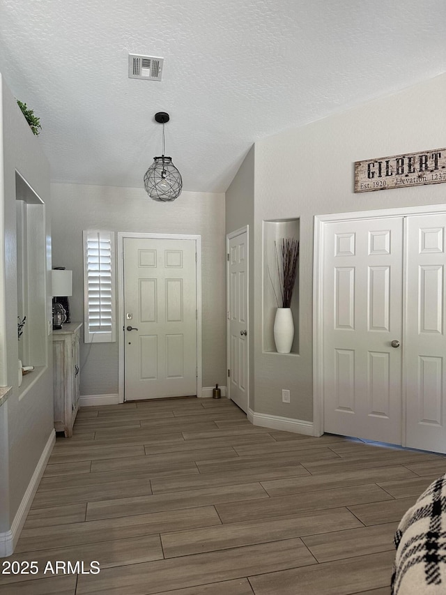 18132 E Vencino St, Gilbert, AZ 85298 - foyer featuring baseboards, light wood-style flooring, and a textured ceiling