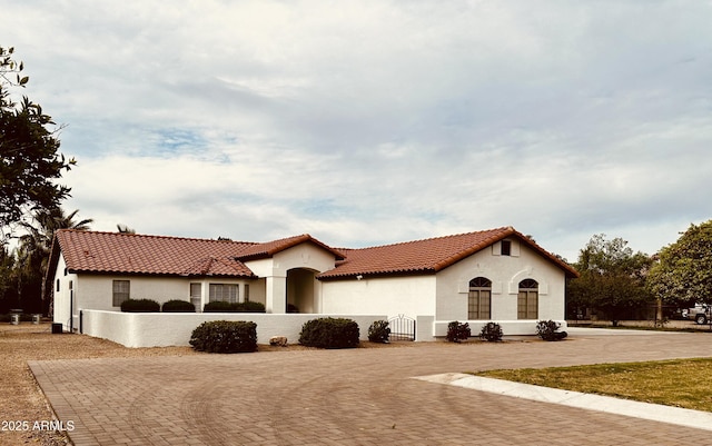 18132 E Vencino St, Gilbert, AZ 85298 - mediterranean / spanish house featuring a fenced front yard, stucco siding, and a tiled roof