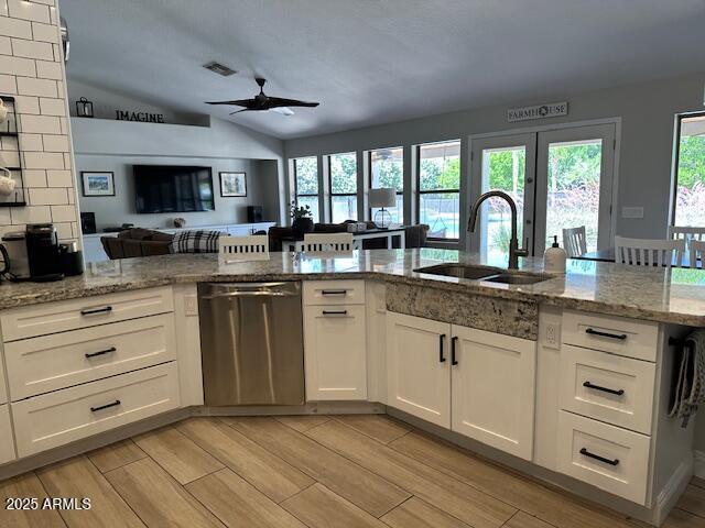 18132 E Vencino St, Gilbert, AZ 85298 - kitchen with stainless steel dishwasher, a sink, a ceiling fan, open floor plan, and white cabinetry