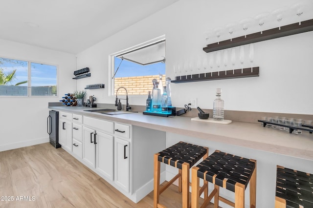 kitchen featuring a healthy amount of sunlight, white cabinets, a sink, and open shelves