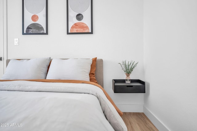 bedroom with baseboards and wood finished floors