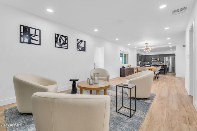 living room featuring visible vents, light wood-style flooring, and recessed lighting