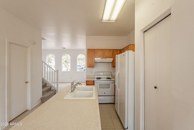 kitchen with sink, light tile patterned floors, and white appliances