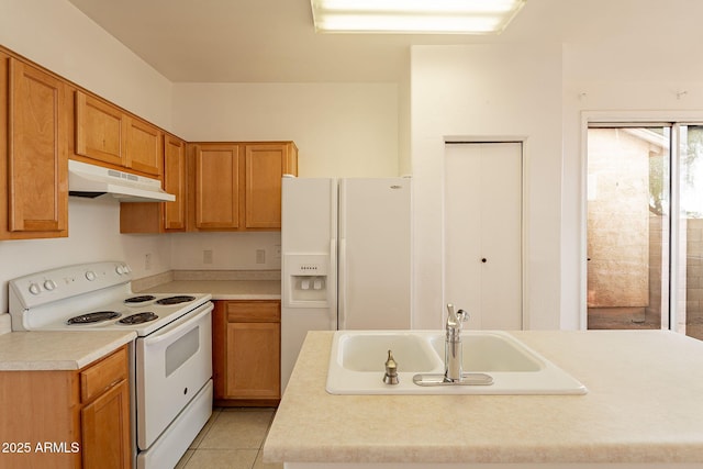 kitchen with an island with sink, sink, light tile patterned floors, and white appliances