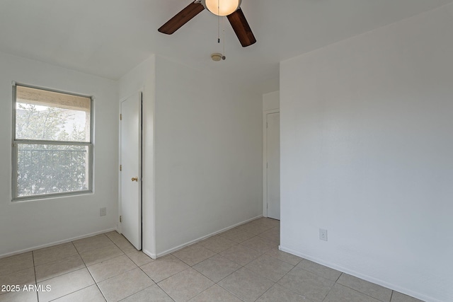 tiled spare room with ceiling fan