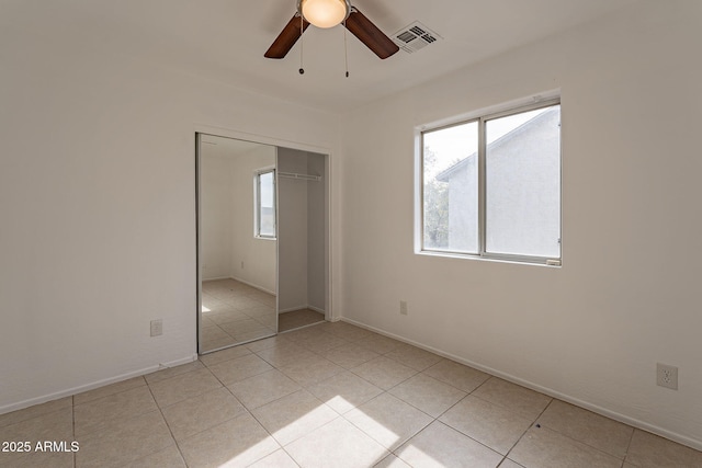 unfurnished bedroom featuring ceiling fan, a closet, and light tile patterned floors