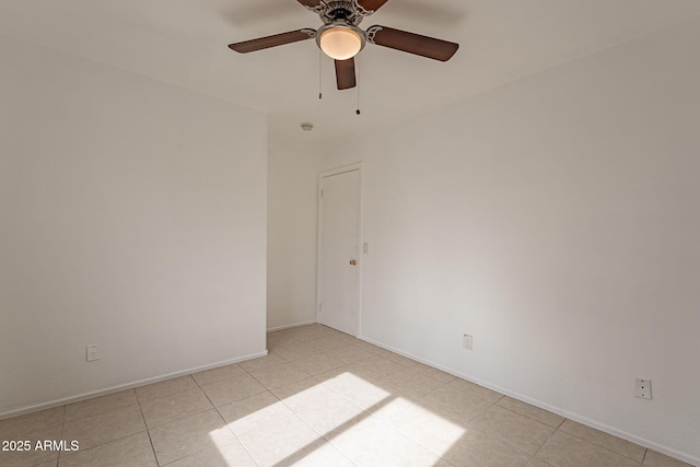 tiled spare room featuring ceiling fan