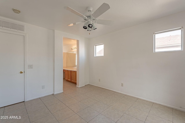 unfurnished bedroom with light tile patterned floors, ceiling fan, and ensuite bathroom