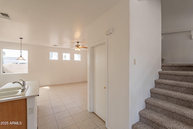 staircase featuring tile patterned flooring, sink, and ceiling fan