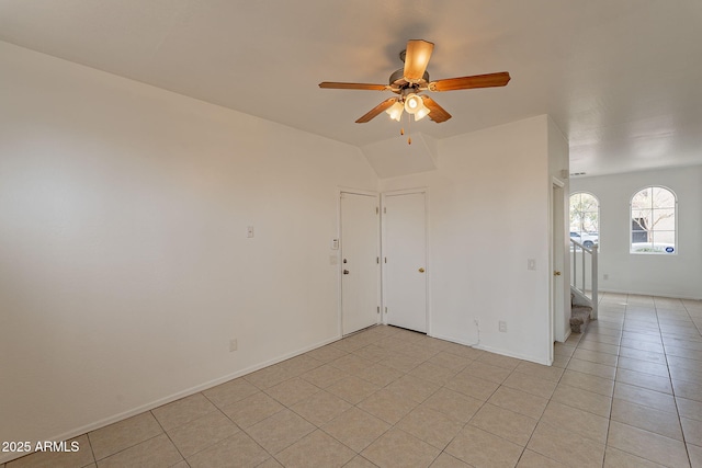 tiled spare room with ceiling fan