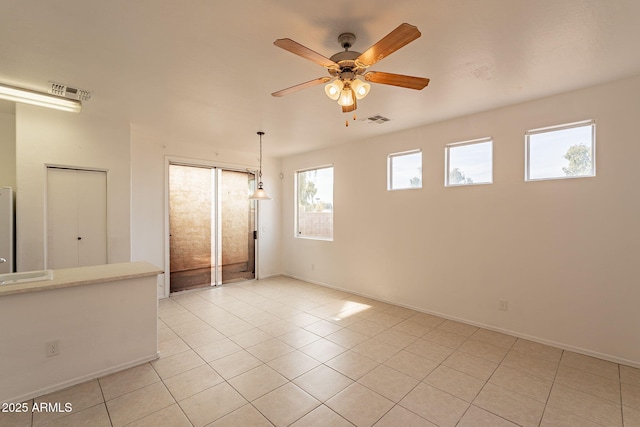 empty room featuring light tile patterned floors and ceiling fan