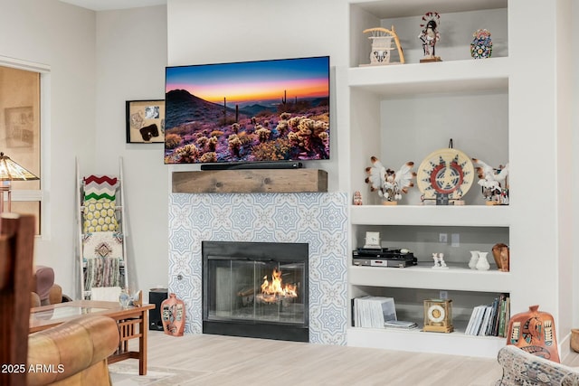 living room featuring hardwood / wood-style flooring and a tiled fireplace