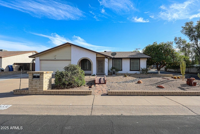 view of front of home featuring a garage, driveway, and stucco siding