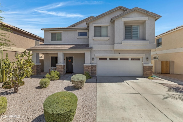 7715 S 69th Ln, Laveen, AZ 85339 - view of front of house with driveway, covered porch, stone siding, stucco siding, and an attached garage
