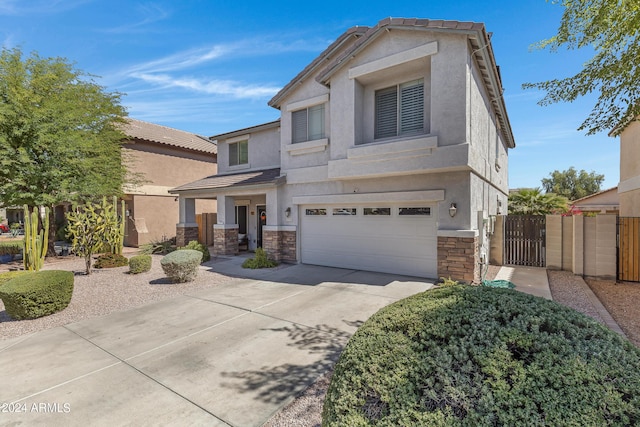 7715 S 69th Ln, Laveen, AZ 85339 - view of front of house with stone siding, a gate, driveway, an attached garage, and stucco siding