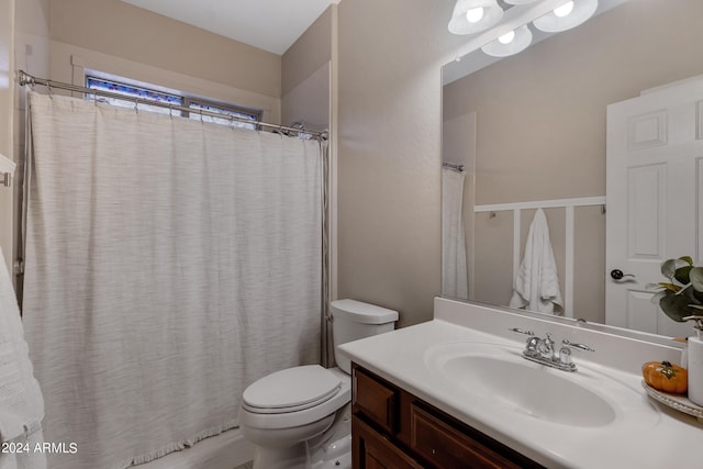 bathroom featuring curtained shower, vanity, and toilet