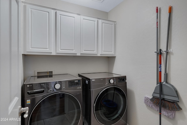 washroom with cabinets and washer and dryer