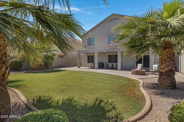 7715 S 69th Ln, Laveen, AZ 85339 - rear view of property featuring a fenced backyard, a fire pit, stucco siding, and a patio