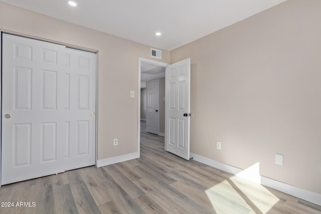 unfurnished bedroom with light hardwood / wood-style floors and a closet