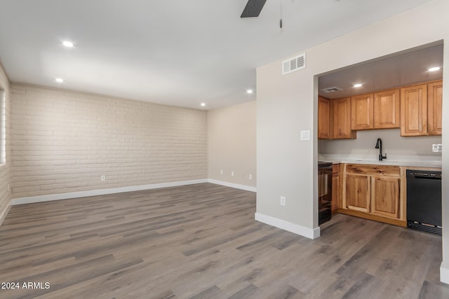 kitchen featuring brick wall, wood-type flooring, and black appliances