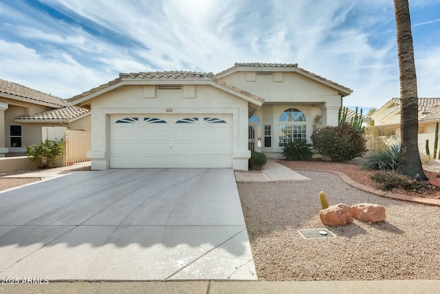 view of front of property featuring driveway, an attached garage, a tiled roof, and stucco siding