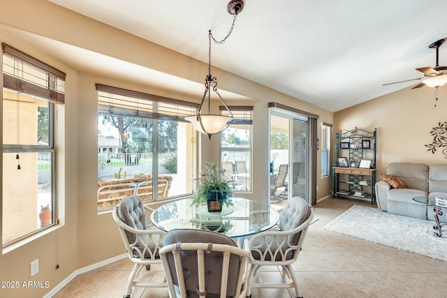 dining room featuring a healthy amount of sunlight, vaulted ceiling, and light tile patterned flooring