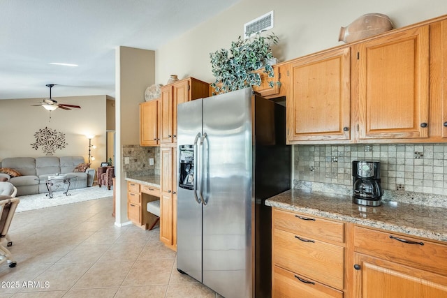 kitchen featuring light tile patterned flooring, light stone counters, tasteful backsplash, stainless steel fridge with ice dispenser, and ceiling fan