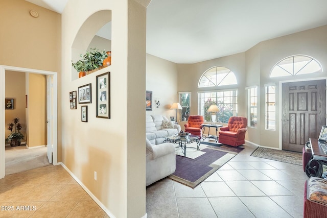 living room with light tile patterned floors and a towering ceiling