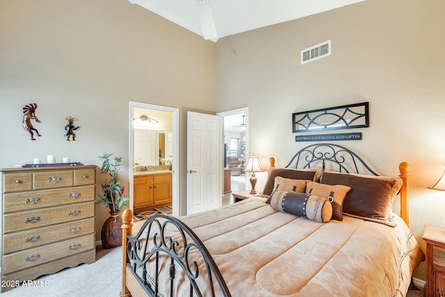 bedroom with high vaulted ceiling, visible vents, connected bathroom, and light colored carpet