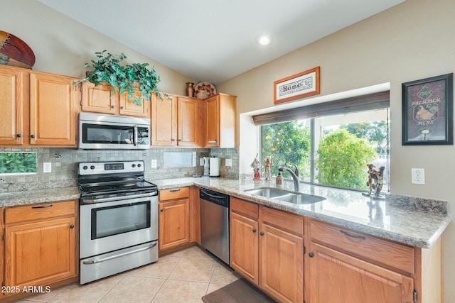 kitchen with light tile patterned floors, light stone counters, a sink, stainless steel appliances, and backsplash