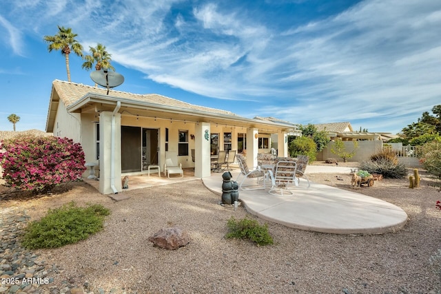 rear view of property with a patio area, fence, and stucco siding