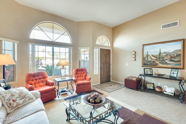 living room with light tile patterned floors and a high ceiling