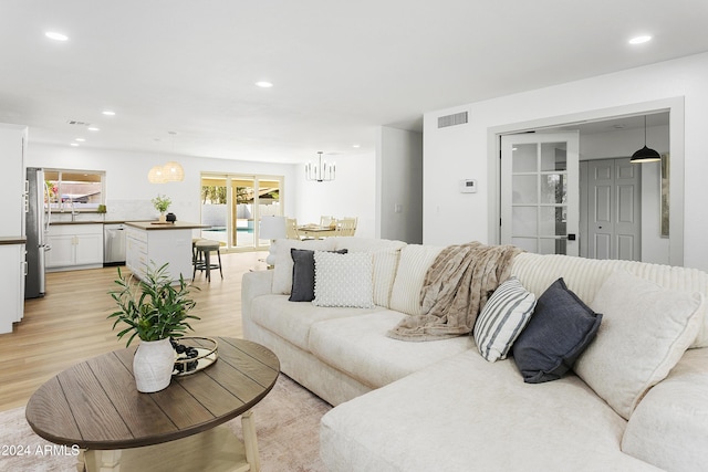 living room with light hardwood / wood-style flooring and a chandelier