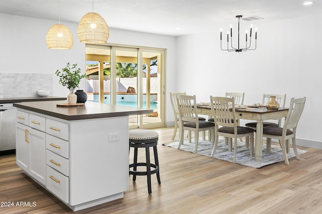 kitchen with white cabinetry, an inviting chandelier, light hardwood / wood-style flooring, pendant lighting, and a kitchen island