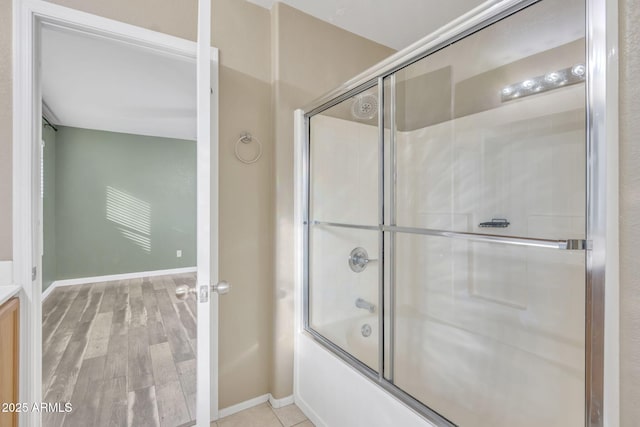 bathroom featuring bath / shower combo with glass door and hardwood / wood-style flooring