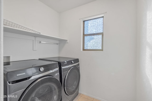 clothes washing area featuring washer and clothes dryer and light tile patterned floors