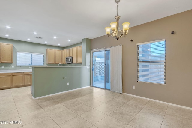 kitchen featuring pendant lighting, a chandelier, light brown cabinetry, and plenty of natural light