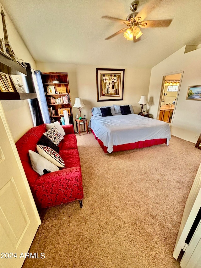 carpeted bedroom with ceiling fan, ensuite bathroom, and vaulted ceiling