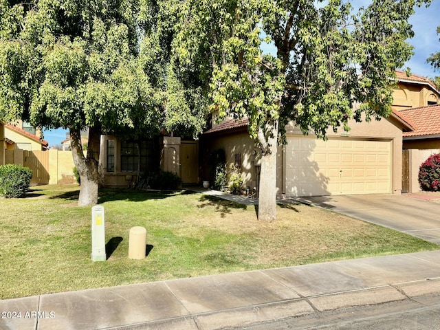 obstructed view of property with a front lawn and a garage