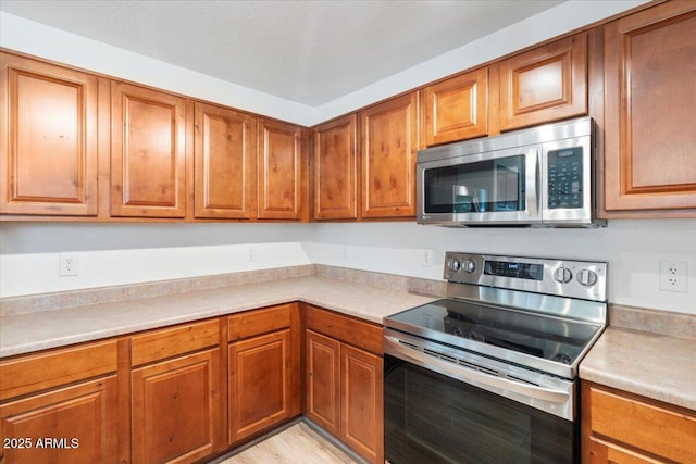 180 S 18th St, Coolidge, AZ 85128 - kitchen featuring appliances with stainless steel finishes, brown cabinets, and light countertops