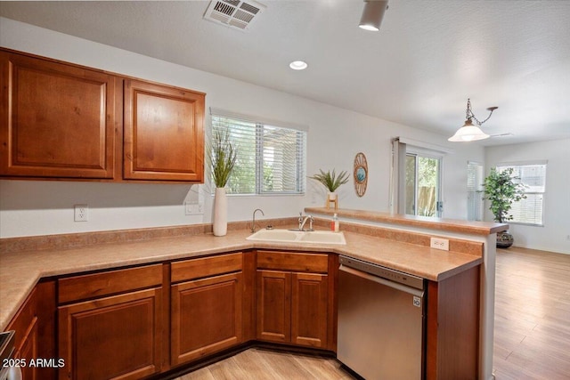 180 S 18th St, Coolidge, AZ 85128 - kitchen with dishwasher, a sink, a peninsula, and brown cabinets