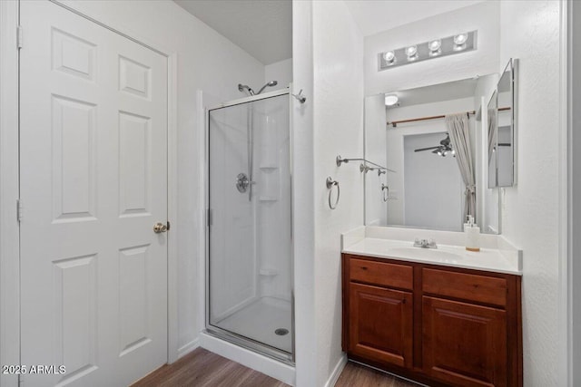 180 S 18th St, Coolidge, AZ 85128 - bathroom featuring wood finished floors, a shower stall, vanity, and a ceiling fan