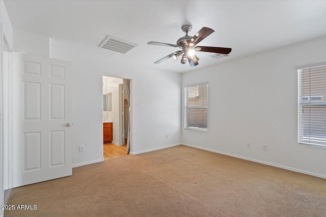180 S 18th St, Coolidge, AZ 85128 - unfurnished bedroom with light carpet, baseboards, connected bathroom, and a ceiling fan