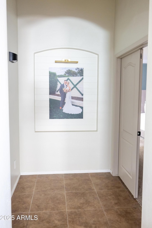 hall featuring tile patterned flooring and baseboards