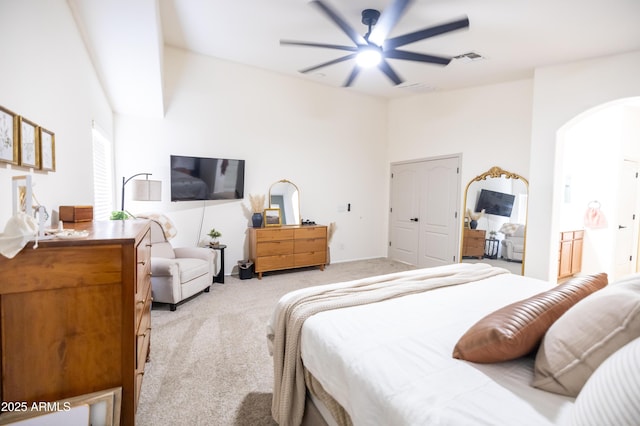 bedroom featuring arched walkways, light colored carpet, ceiling fan, and visible vents